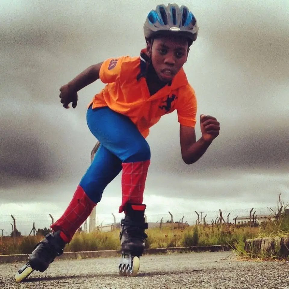 A young skater in an orange shirt leaning into a turn