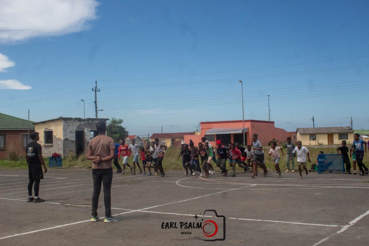 Young runners sprinting a race across an outdoor court