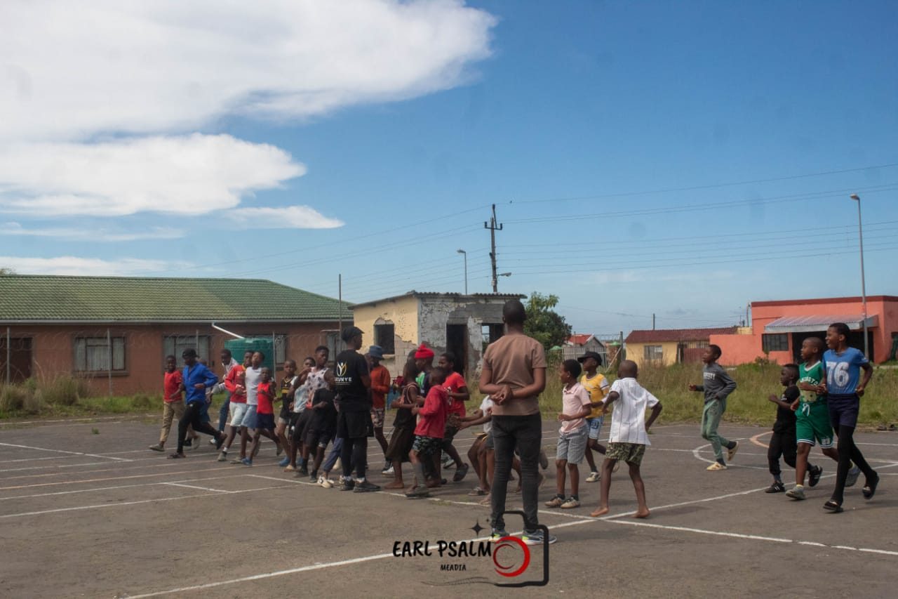 Young runners taking part in a supervised fitness drill on a court