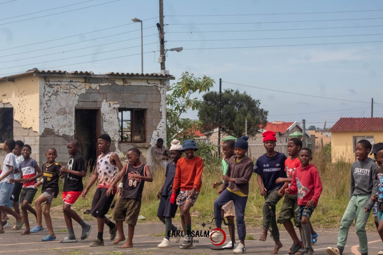 A long line of young runners warming up together on an outdoor court